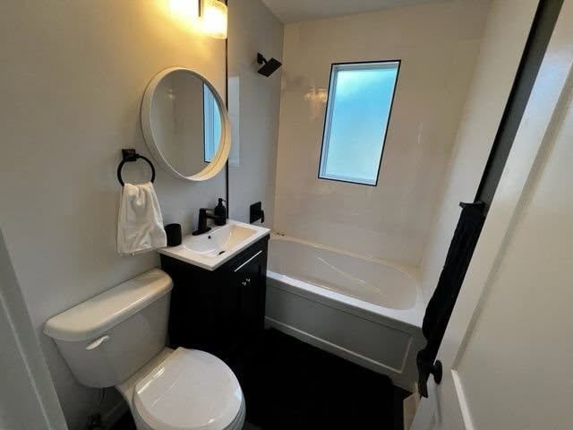 Bathroom renovation — modern black fixtures, round mirror, soaker tub