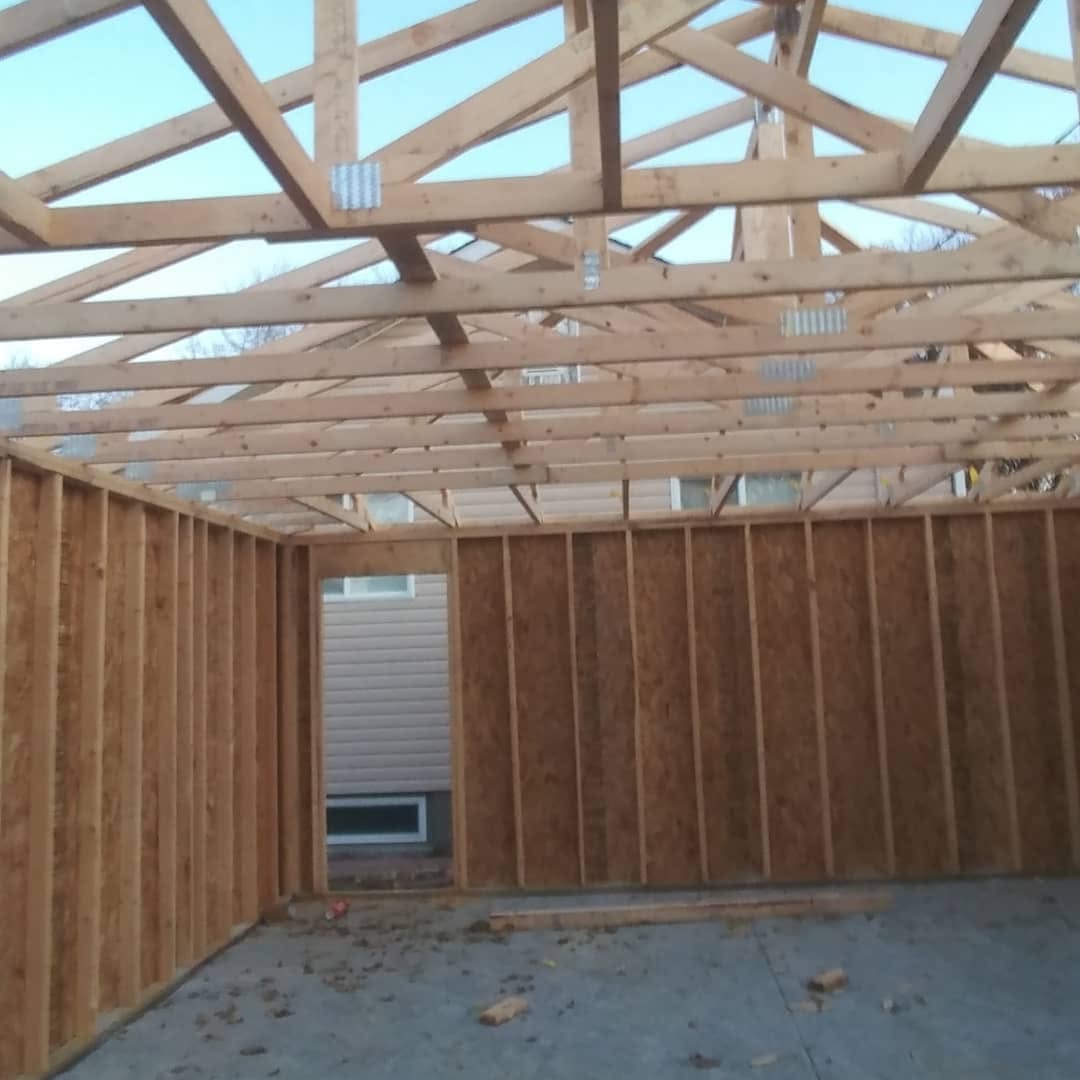 Garage interior framing — exposed trusses and stud walls before sheathing