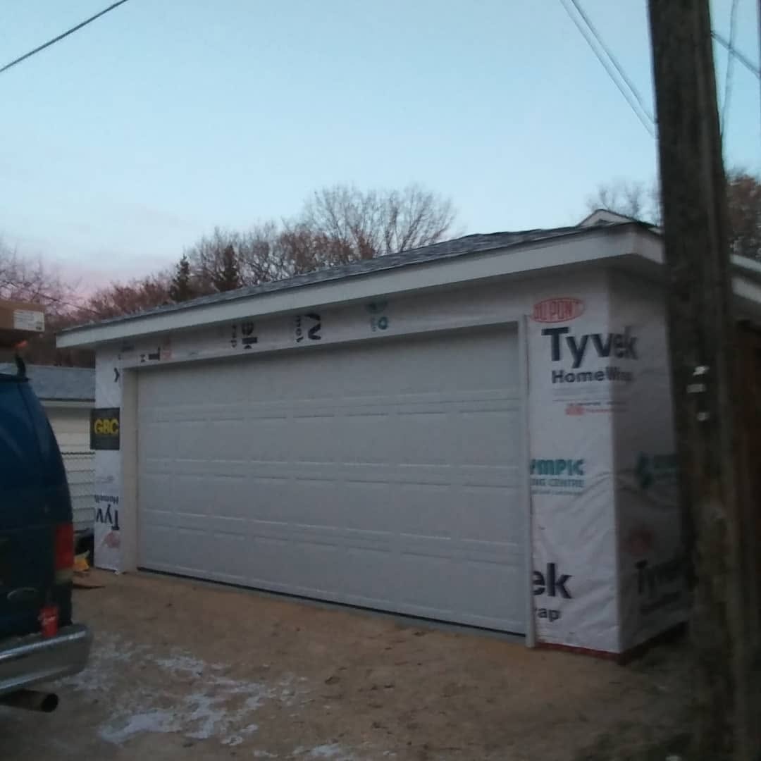 Garage nearing completion — Tyvek housewrap installed, door hung