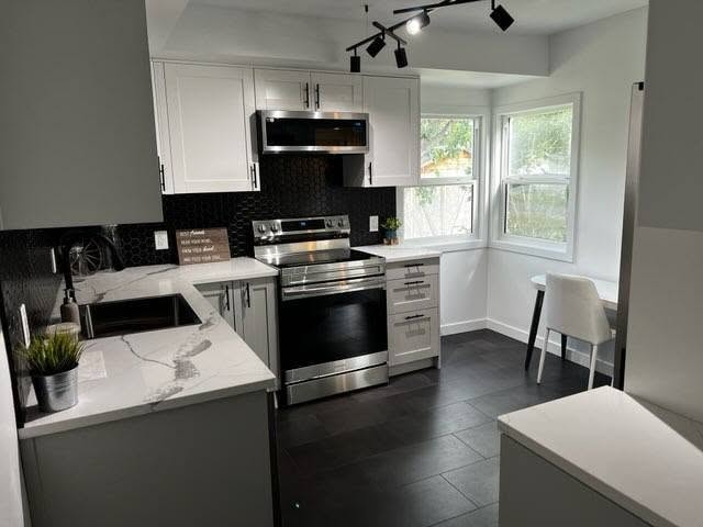 Kitchen renovation — black hex backsplash, marble countertops, stainless appliances